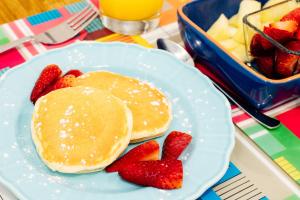 a plate with pancakes and strawberries and a bowl of fruit at Sintra1012 Boutique Guesthouse in Sintra