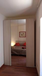 1 dormitorio con 1 cama y un gran armario de cristal en A casa di Lori, en Catania