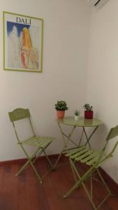 dos sillas y una mesa y una mesa con plantas en A casa di Lori, en Catania