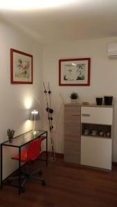 een kamer met een tafel, een rode stoel en een bureau bij A casa di Lori in Catania