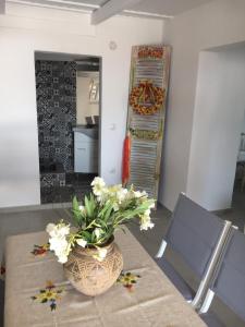 a room with a table with a vase of flowers on it at Ergina Summer Resort in Antiparos