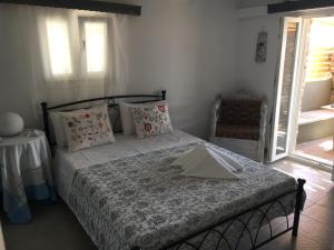a bedroom with a bed and a table and a window at Ergina Summer Resort in Antiparos