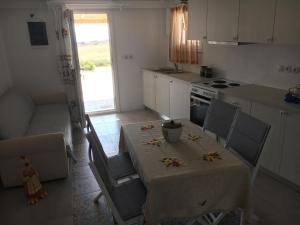 a kitchen with a table and chairs and a kitchen with a stove at Ergina Summer Resort in Antiparos