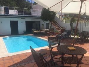 una piscina con sillas y una mesa junto a un edificio en Hotel O Noso Portosin, en Portosín