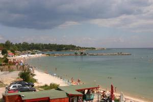 a beach with a group of people in the water at Harmony Beach Family Hotel in Nesebar