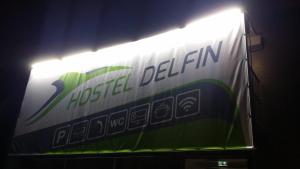a sign for a higel deliven lit up at night at Delfin in Štúrovo