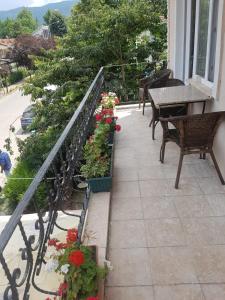 balcón con flores, mesa y bancos en Kumbaz Pansiyon en Sapanca
