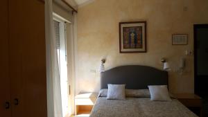 a bedroom with a bed with two pillows on it at Hotel Marietta in Caorle