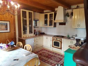 a kitchen with white cabinets and a table with a table sidx sidx at Rogla - Koča Mojca Pokrajculja in Zreče