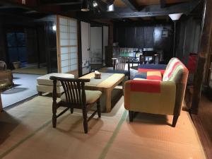 a living room with chairs and a table and a couch at Yakuno House in Fukuchiyama