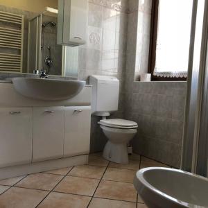 y baño con lavabo, aseo y bañera. en Monolocale Belvedere vda La Thuile CIR 0067, en La Thuile