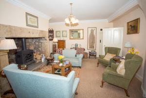 uma sala de estar com cadeiras e uma lareira em Errington House em Hexham