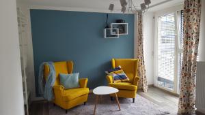 a living room with two chairs and a blue wall at CastleView in Ljubljana