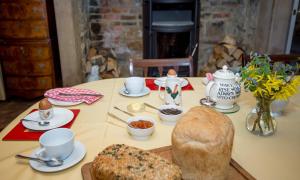 stół z chlebem, kubkami i miskami z jedzeniem w obiekcie Errington House w mieście Hexham