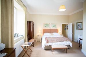 a bedroom with a bed and a desk and a window at Errington House in Hexham