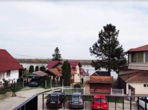 een rij huizen met auto's geparkeerd op een parkeerplaats bij Prenočište Dunav in Novi Banovci