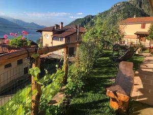 a garden with a wooden bench and a fence at Agriturismo Botton D'Oro in Dongo
