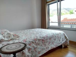 a bedroom with a bed with a table and a window at Casa D.Dinis in Vide