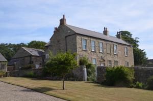 an old brick building with a tree in front of it at Errington House in Hexham