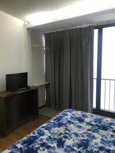 a bedroom with a bed and a flat screen tv at Nine Place Sukhumvit 40 in Bangkok