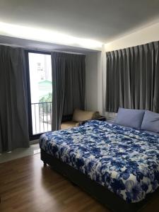 a bedroom with a bed with a blue floral bedspread at Nine Place Sukhumvit 40 in Bangkok