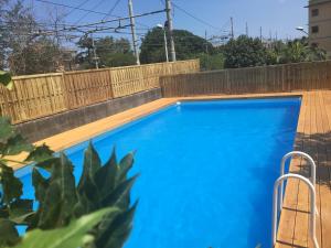 una piscina azul junto a una valla de madera en B&B Villa Maria, en Giarre