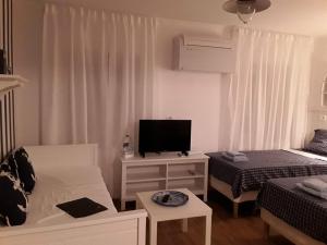 a living room with a bed and a tv in it at Tri Gracije in Koper