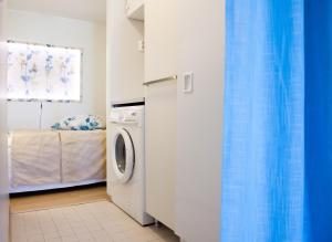 a laundry room with a washing machine and a bed at Holiday Home Birdie in Naantali