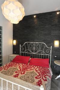 a bedroom with a bed with red pillows and a chandelier at Marconi by PizzoApartments in Pizzo