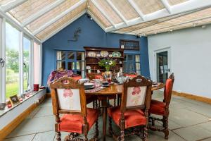 una sala da pranzo con tavolo e sedie di Corner Farm a Halesworth