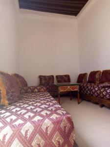 a room with a bed and a couch and a table at Maison Saadia in Rabat
