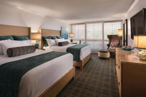a hotel room with two beds and a sitting area at The Cliffs Hotel and Spa in Pismo Beach