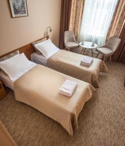 a hotel room with two beds and two tables at Mini-Hotel Kievskiy in Kyiv