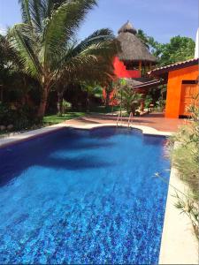 a large blue swimming pool in front of a house at Unelma Bungalows in Bucerías