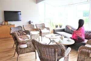 a woman sitting on a couch in a living room at Veghús Guesthouse in Sólheimar