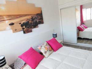 アロナにあるRosamar Luxury Apartmentのリビングルーム(ピンクの枕と白いソファ付)
