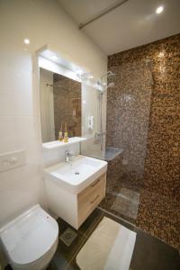 a bathroom with a toilet and a sink and a shower at Hotel Urban in Bužim