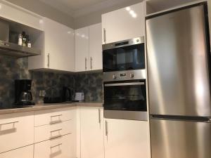 a kitchen with white cabinets and a stainless steel refrigerator at A for Argostoli in Argostoli