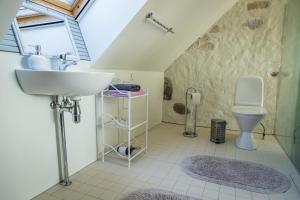 
a bathroom with a toilet, sink, and tub at Dagen Haus Guesthouse in Orjaku
