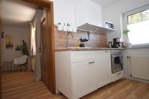 a kitchen with white cabinets and a sink at Ferienwohnung Kleine Auszeit in Hagenburg