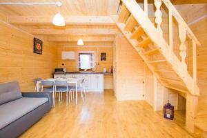 a living room with a staircase in a wooden house at Domki KARO in Rowy +29 photos