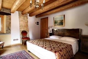 1 dormitorio con 1 cama grande y techo de madera en Resort Villa Manin, en Passariano