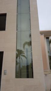 a reflection of a palm tree in the window of a building at Quinta de Palames in Sesimbra +28 photos
