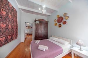 a bedroom with a bed with a purple blanket at KasteliSuites in Chania