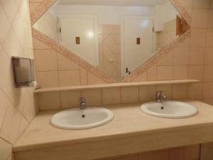 łazienka z 2 umywalkami i lustrem w obiekcie Estia hotel w mieście Fourka