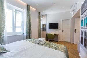 a bedroom with a bed and a desk and a television at AML apartments in Split