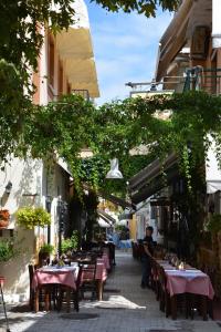 an outdoor restaurant with tables and chairs and vines at Dionyssos in Limenas