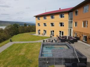 a building with a swimming pool next to a building at Hotel Hallormsstadur in Hallormsstaður