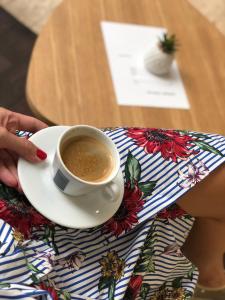 una persona che tiene una tazza di caffè sul tavolo di City Code In Joy a Belgrado
