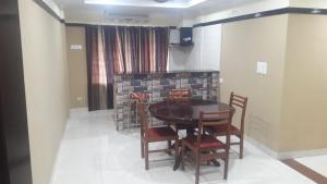 a dining room with a table and chairs at Bennies Inn in Kottayam